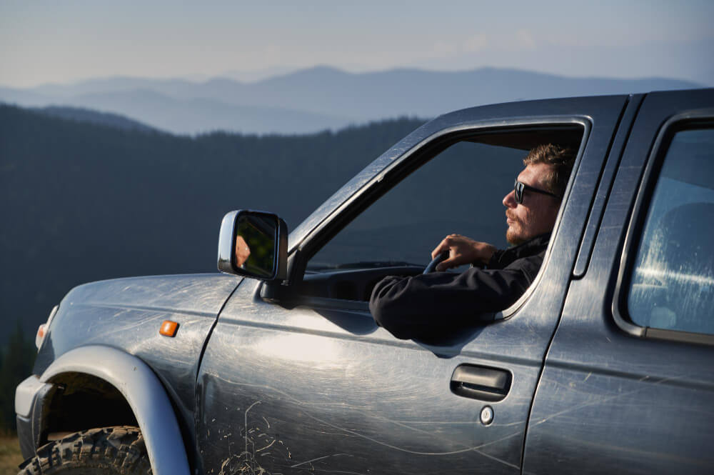 man with sunglasses driving suv